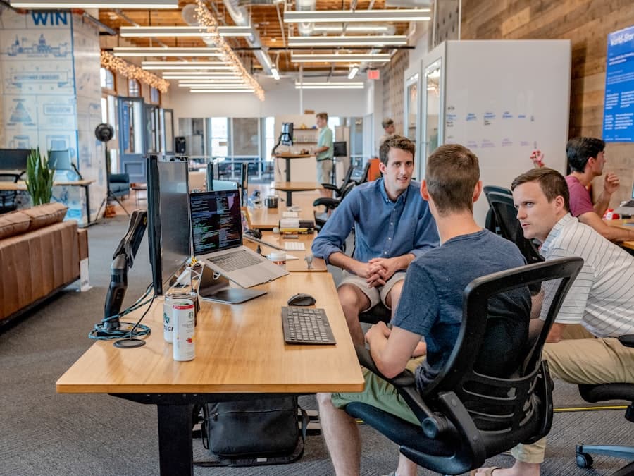 Colleagues talking at a shared desk