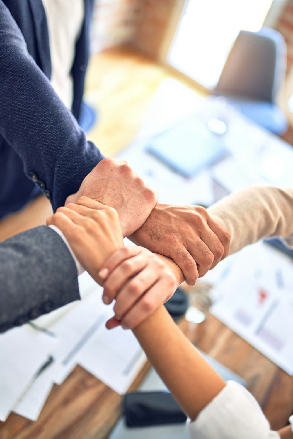 Business partners joining hands over a table